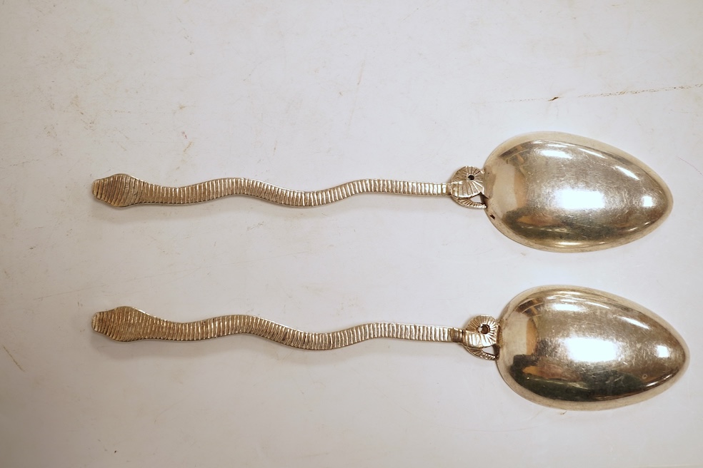 An 18th century silver apostle spoon, indistinct marks, 17cm, a continental white metal spoon with scroll handle and a pair of unmarked white metal spoons with serpent handles.